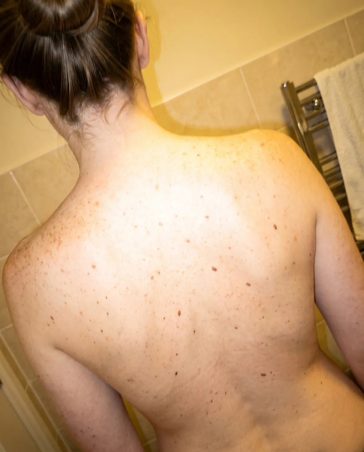 A back photographed at home on a phone, with uneven light and flash glare