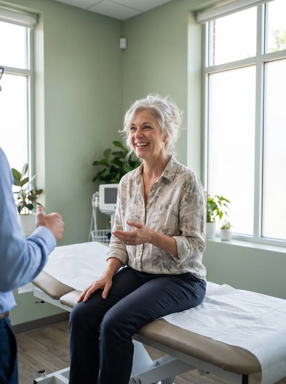 A relaxed patient chatting with her doctor on an examination couch